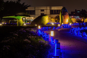 Night view of a whale shape structure with plants on it