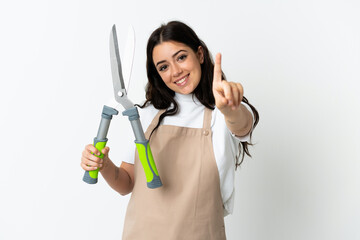 Young caucasian woman holding a plant isolated on white background showing and lifting a finger