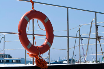 lifebuoy on boat railings in front of blue sky