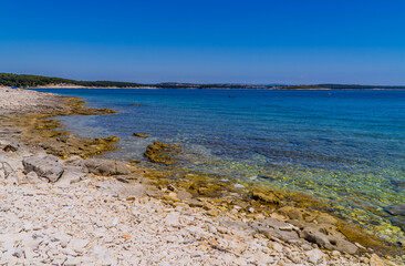 Rocky stone beach with different colors of turqouise blue waters in Kamenjak, National Park, Istria, Croatia