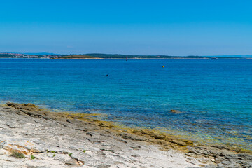 Rocky stone beach with different colors of turqouise blue waters in Kamenjak, National Park, Istria, Croatia