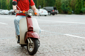 Cropped photo of a man riding a scooter