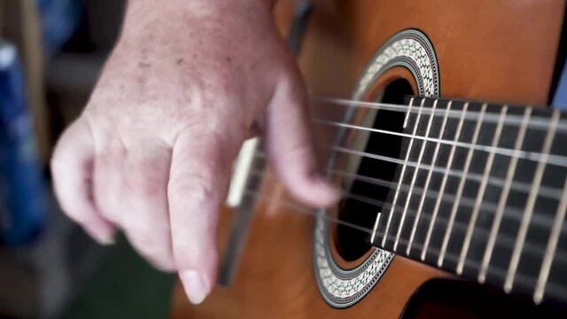 Acoustic Guitar Strumming. Close-up footage of a hand strumming on the classical guitar.