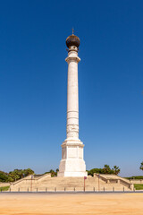 Fototapeta na wymiar Monument to the discoverers in La Rabida, Huelva. Large column with an orb at its top in an environment surrounded by gardens. Huelva, Andalusia, Spain.