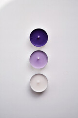 beautiful little round purple and white candles on a white background
