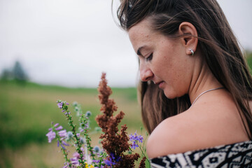 Beautiful, slender girl in a meadow dress with wildflowers