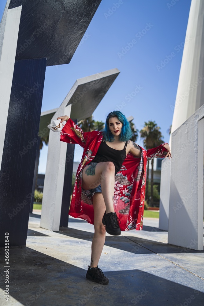 Poster Attractive and beautiful woman with blue hair wearing a red loose kimono and holding a scary mask