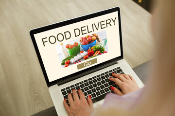 Close up woman sitting and orde food online on laptop computer in add to cart function webpage at coffee shop,Digital marketing concept.digital lifestyle living
