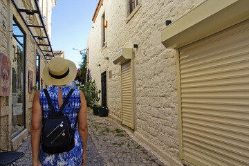  Young woman walking in narrow street in Alacati, Cesme Turkey