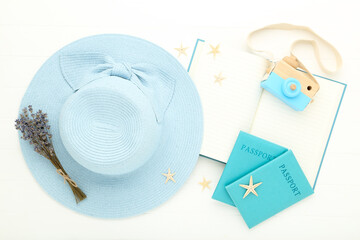 Summer straw hat with lavender flowers, passports, notepad and starfishes on white wooden table