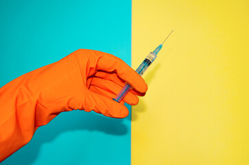 Hand in protective glove holds syringe with antivirus vaccine. Banner with copy space for medical treatment theme.