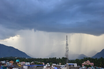 Rain shower falling from dark cumulus clouds
