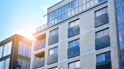 Modern apartment buildings on a sunny day with a blue sky. Facade of a modern apartment building. Glass surface with sunlight.