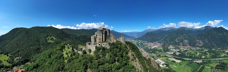Fototapeta na wymiar The Sacra di San Michele (Saint Michael's) Abbey, Turin, Italy, shot aerial with mountains of Susa valley in background. Aerial view