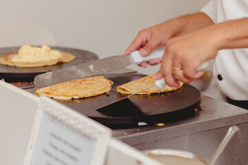 pessoas com espátula de inox virando o crepe 