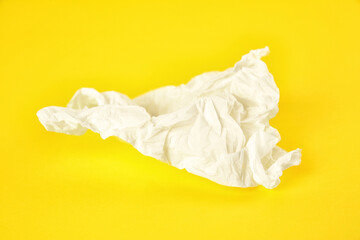 Used paper tissue on yellow background, closeup