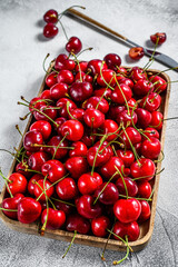 Naklejka na ściany i meble Cherries in a wooden bowl. fresh ripe cherries. Gray background. Top view