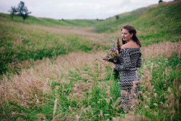 Beautiful, slender girl in a meadow dress with wildflowers