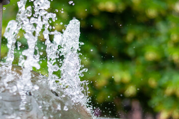 Water gurgling from a street fountain. A splash of water in a fountain, an abstract image.