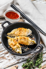 Fried dumplings in a pan, Chinese food cooking.  White background. Top view