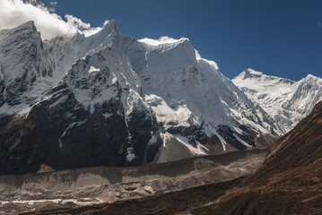 Manaslu summit rises above the far south end of Syancha glacier valley, as seen from Samdo village to Larkya Phedi camp on Manaslu Circuit trek, Manaslu Himal range, Gorkha district, Nepal Himalayas.