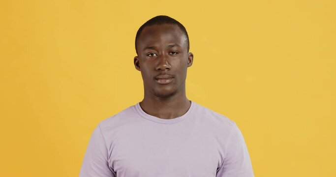 Portrait of handsome african american guy, yellow background