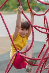 cute girl climbing the net in the playground