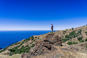 Fototapeta premium Hiker in the Mountains with Ocean background