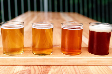 Beer tasting. Diferent beer in 100 mililiter glases over wooden table.