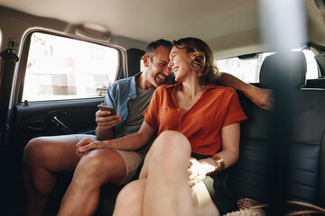 Cheerful couple in rear seat of car