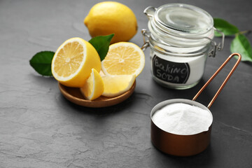 Baking soda and cut lemon on black table