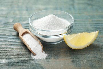 Baking soda and cut lemon on blue wooden table