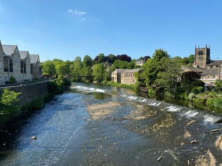 River Aire as it flows through Bingley, with houses, trees, and a tower clock in, Bingley,...