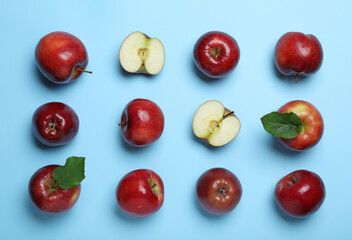 Tasty red apples on light blue background, flat lay