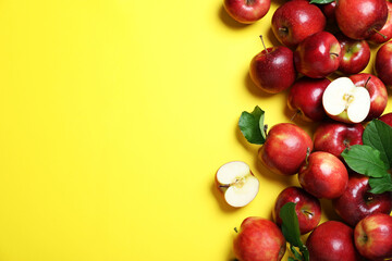 Tasty red apples on yellow background, flat lay. Space for text
