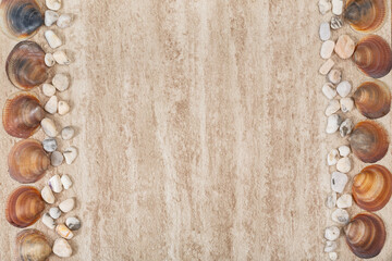 Seashell and smooth stones on beige stone surface. Copy space. Space for text. Rough  light background.