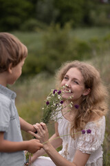 Son gives his mother flowers, happy family, beautiful woman with white hair smiles, laughter and joy, children and parents