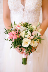 wedding bouquet of flowers in the hands of the bride close-up, white and pink roses, vertical photo, white wedding dress, place for text, wedding day, beautiful girl