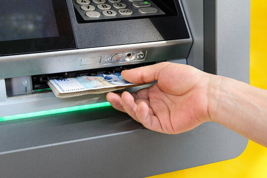 Caucasian man hand taking bulgarian levs from ATM. Receive money at a cash machine outdoors. ATM cash withdrawal.