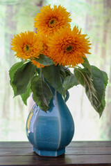 青い花瓶にいけたヒマワリ