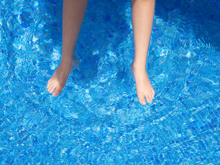 Woman legs playing in the pool