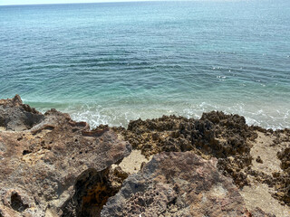 Fototapeta na wymiar A rocky beach with clear turquoise water in Stuart, FL