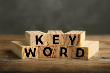 Word KEYWORD made of blocks on wooden table, closeup