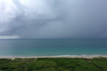 A storm over the colorful Atlantic Ocean with dark clouds.