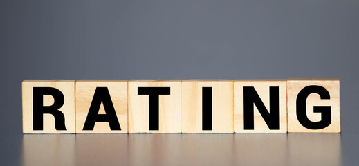 RATING word concept written on wooden cubes blocks lying on a light table and light background