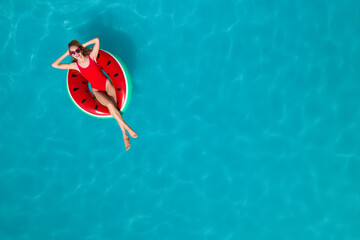 Young happy woman with inflatable ring in swimming pool, top view and space for text. Summer vacation