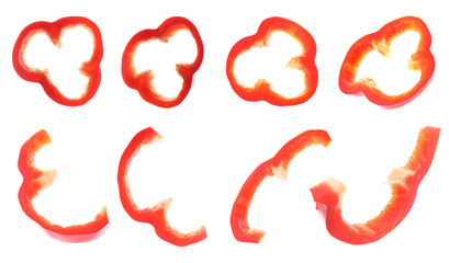 Set or ripe red bell pepper slices flying on white background