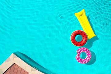 Inflatable rings and mattress floating in swimming pool, top view with space for text. Summer...