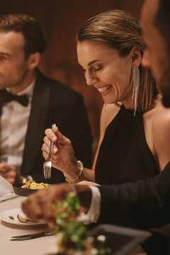 Beautiful woman enjoying dinner with friends at party