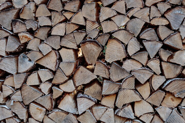 stack of firewood background, close up and full frame.  brown woodpiles for lumber industry